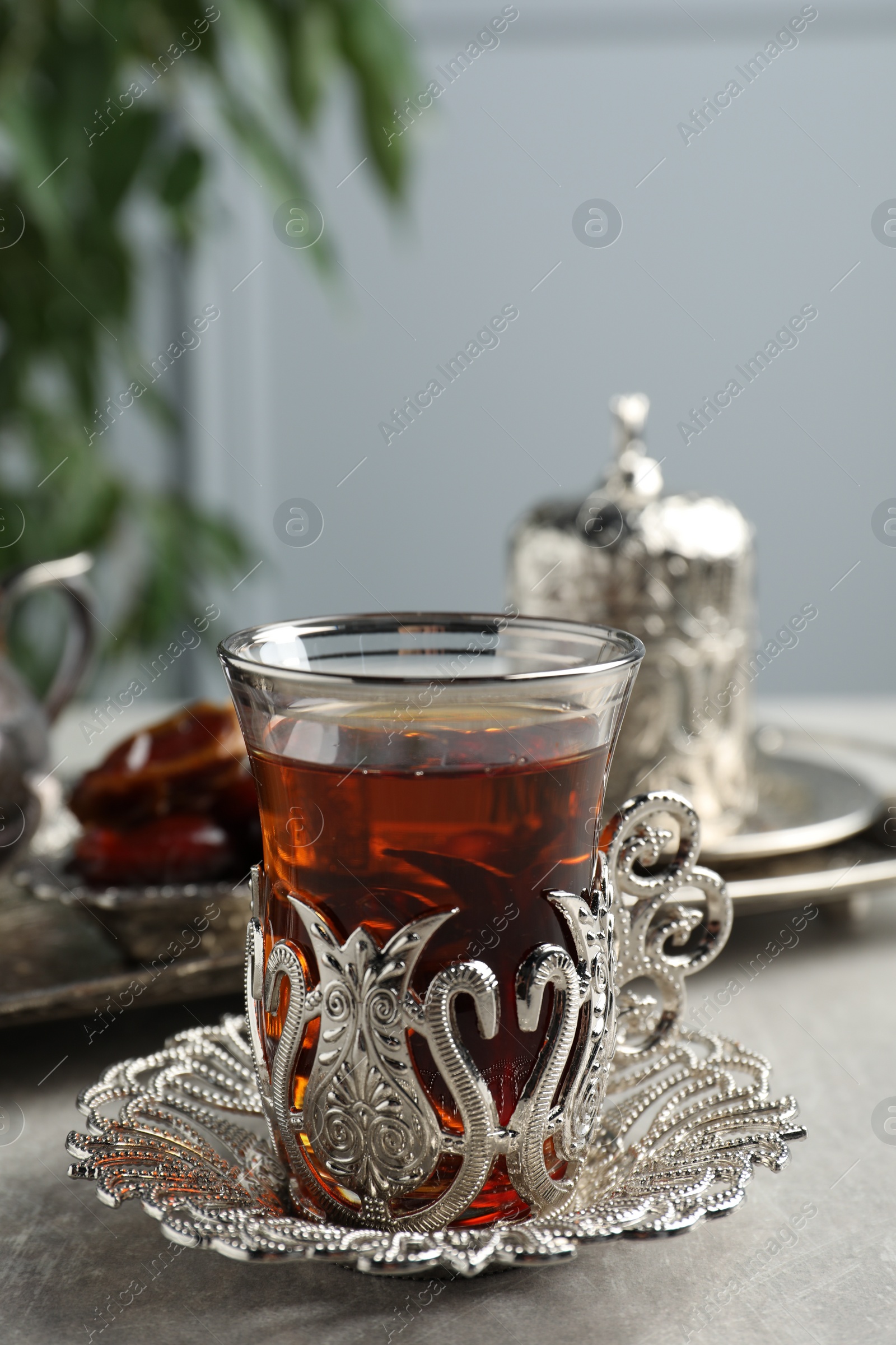 Photo of Tea and date fruits served in vintage tea set on grey table, space for text