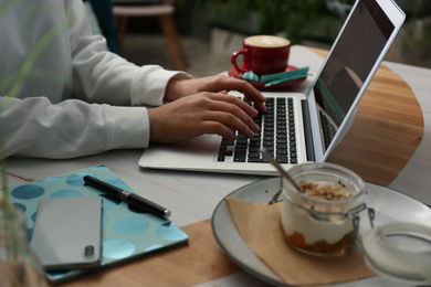 Photo of Blogger working with laptop in cafe, closeup