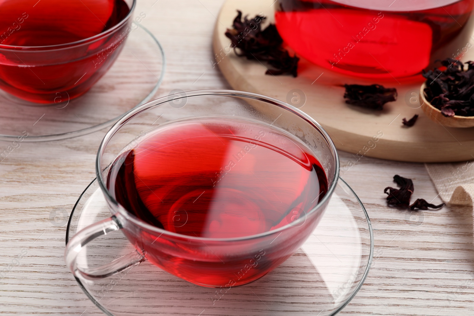 Photo of Fresh hibiscus tea and dry flower leaves on wooden table