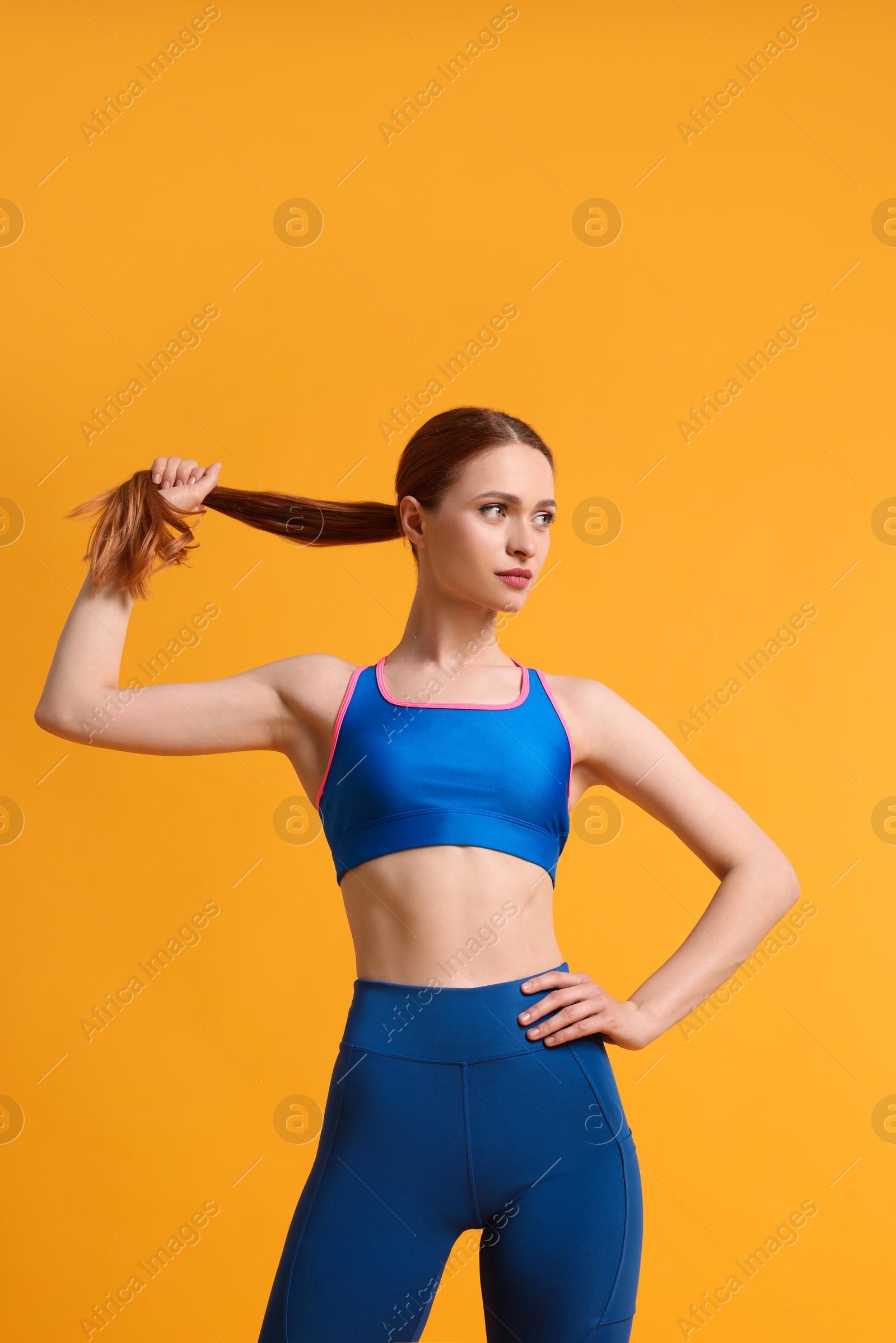 Photo of Young woman wearing sportswear on yellow background