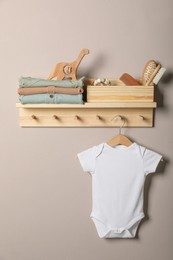 Photo of Baby clothes, toys and accessories on wooden rack