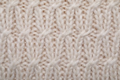 Photo of Beige knitted scarf as background, top view