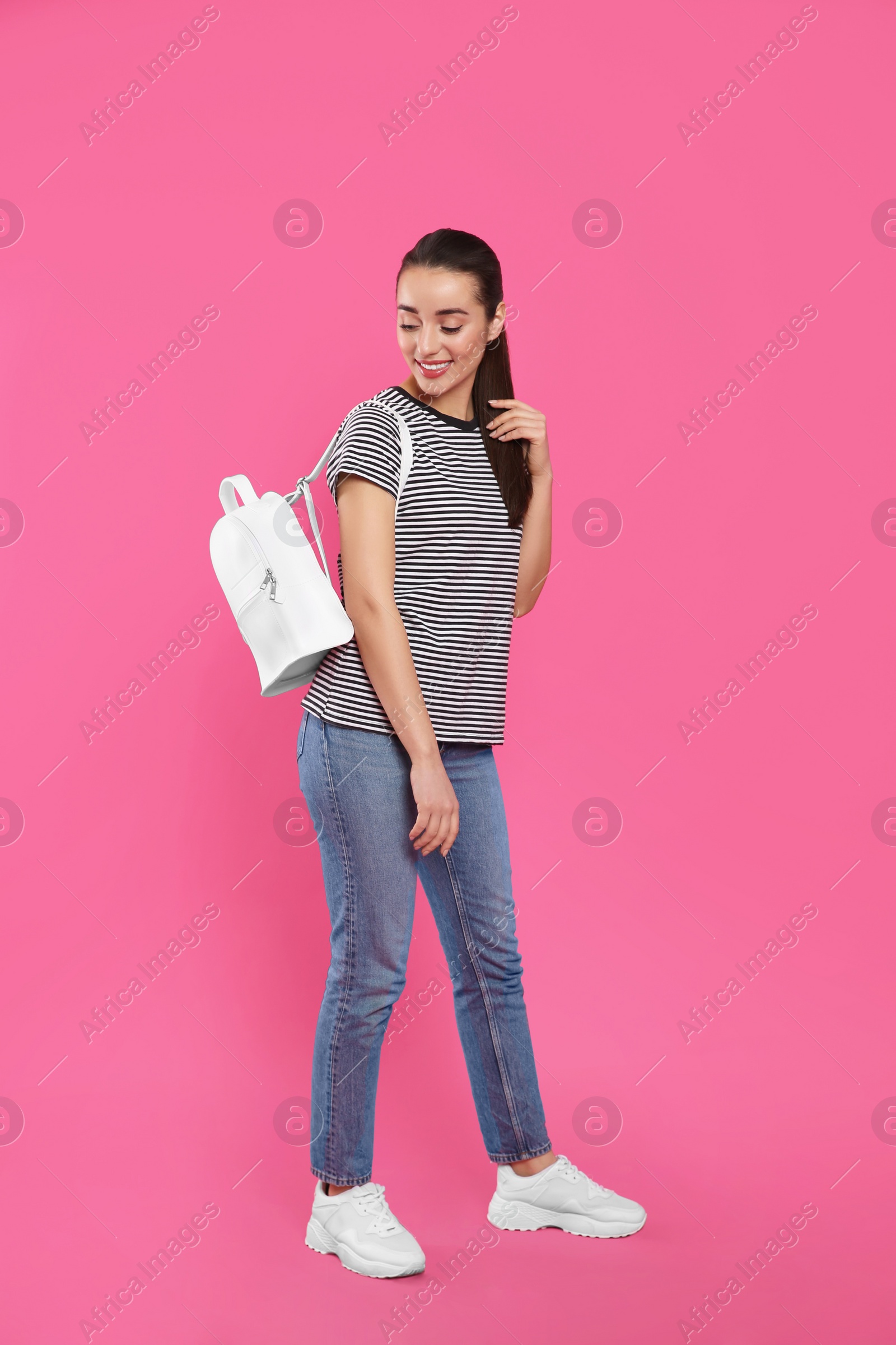 Photo of Beautiful young woman with stylish leather backpack on pink background