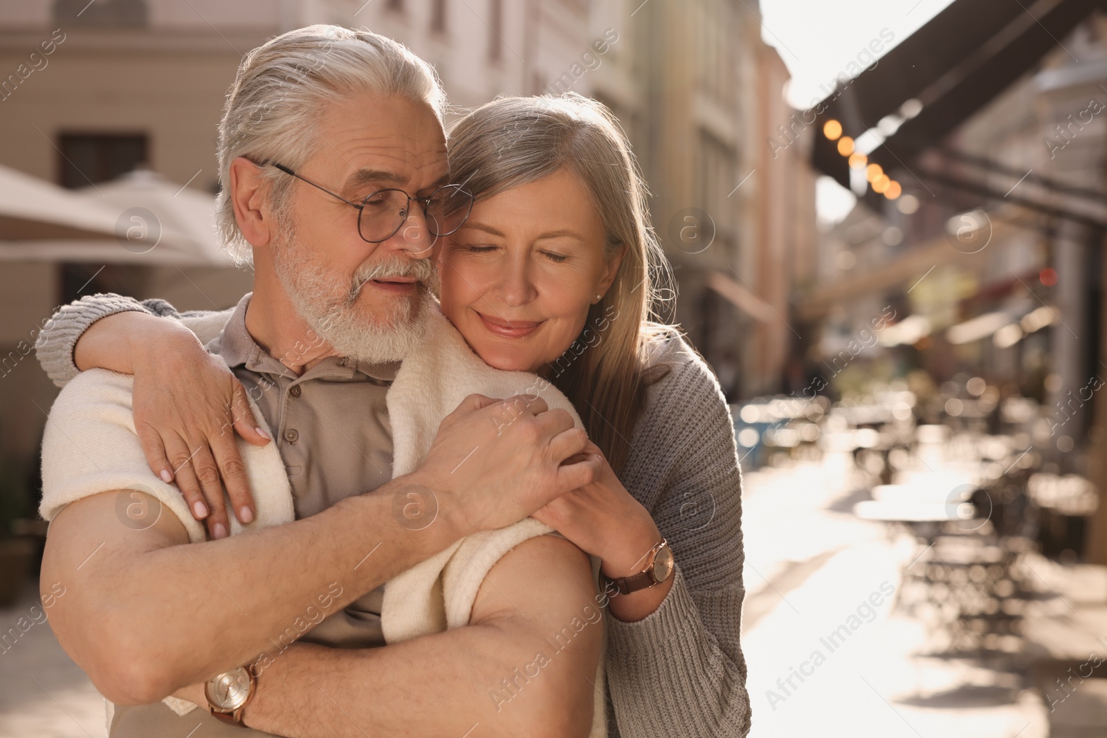 Photo of Affectionate senior couple walking outdoors, space for text