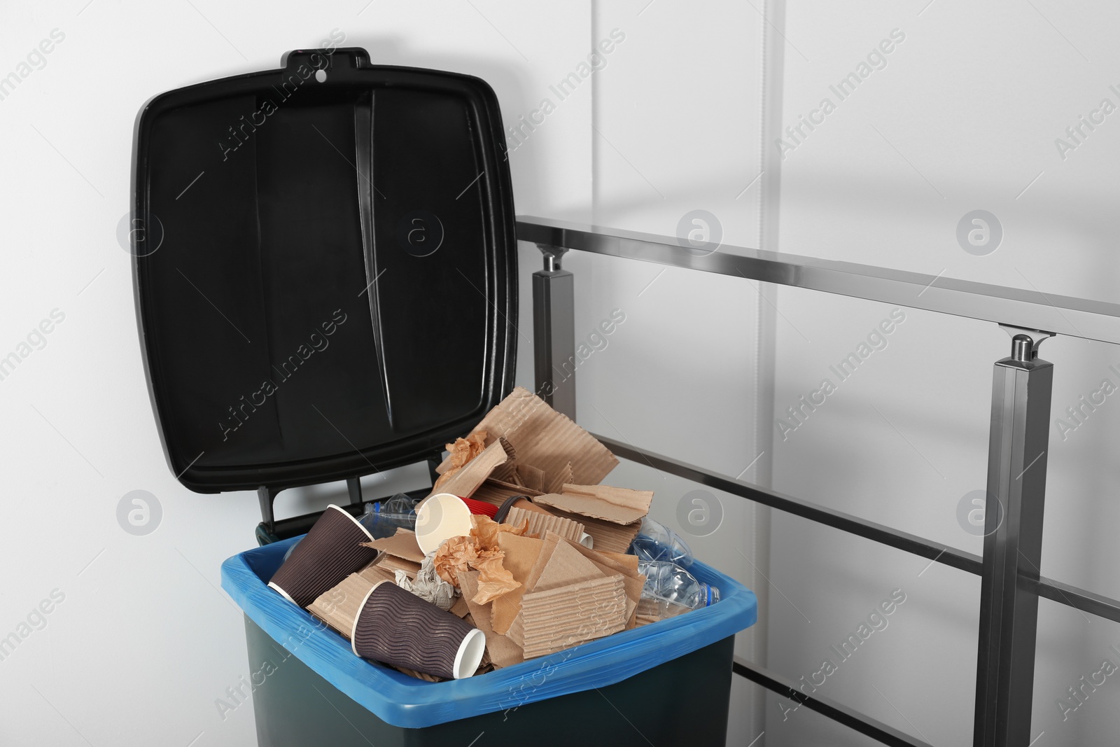 Photo of Trash bin full of garbage indoors. Waste recycling