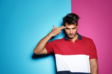 Photo of Young man with trendy hairstyle posing on color background