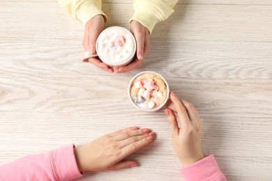 Photo of Women having coffee break at light wooden table, top view