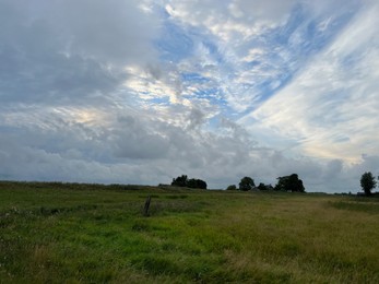 Picturesque view of green field and cloudy sky