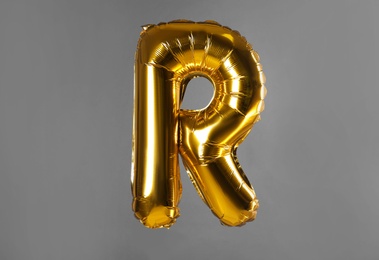 Photo of Golden letter R balloon on grey background