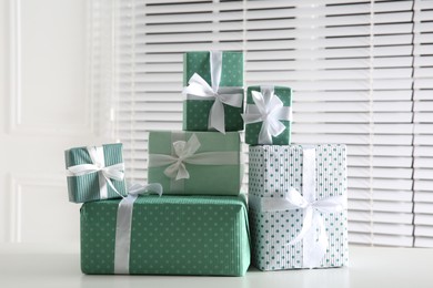 Heap of wrapped gift boxes on white table. Happy holiday