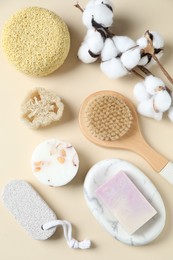 Bath accessories. Flat lay composition with personal care products and cotton flowers on beige background