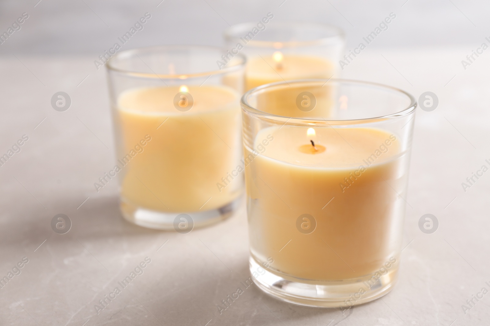 Photo of Three burning candles in glasses on table