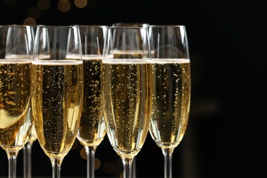 Photo of Glasses of champagne on dark background, closeup. Space for text