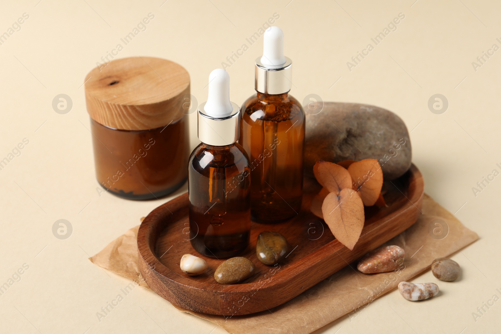 Photo of Composition with bottles of cosmetic serum on beige background