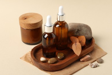 Composition with bottles of cosmetic serum on beige background