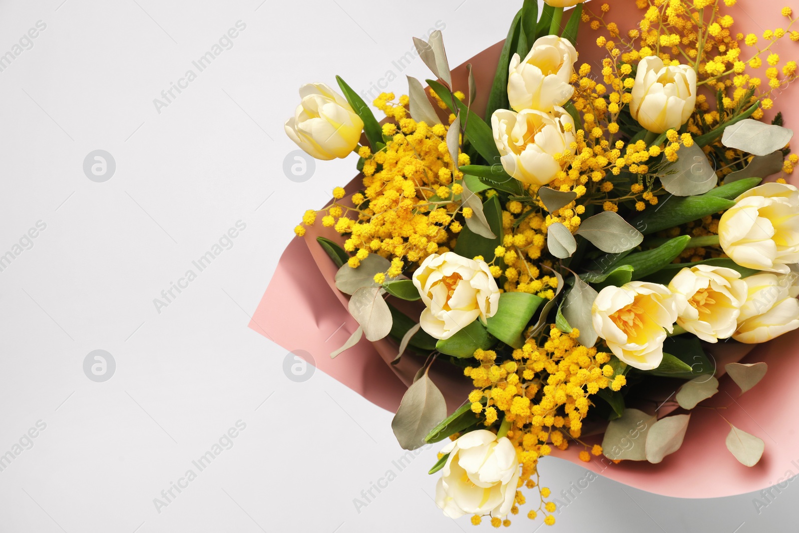 Photo of Bouquet of beautiful spring flowers on light grey background, top view. Space for text