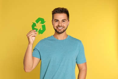 Photo of Young man with recycling symbol on yellow background