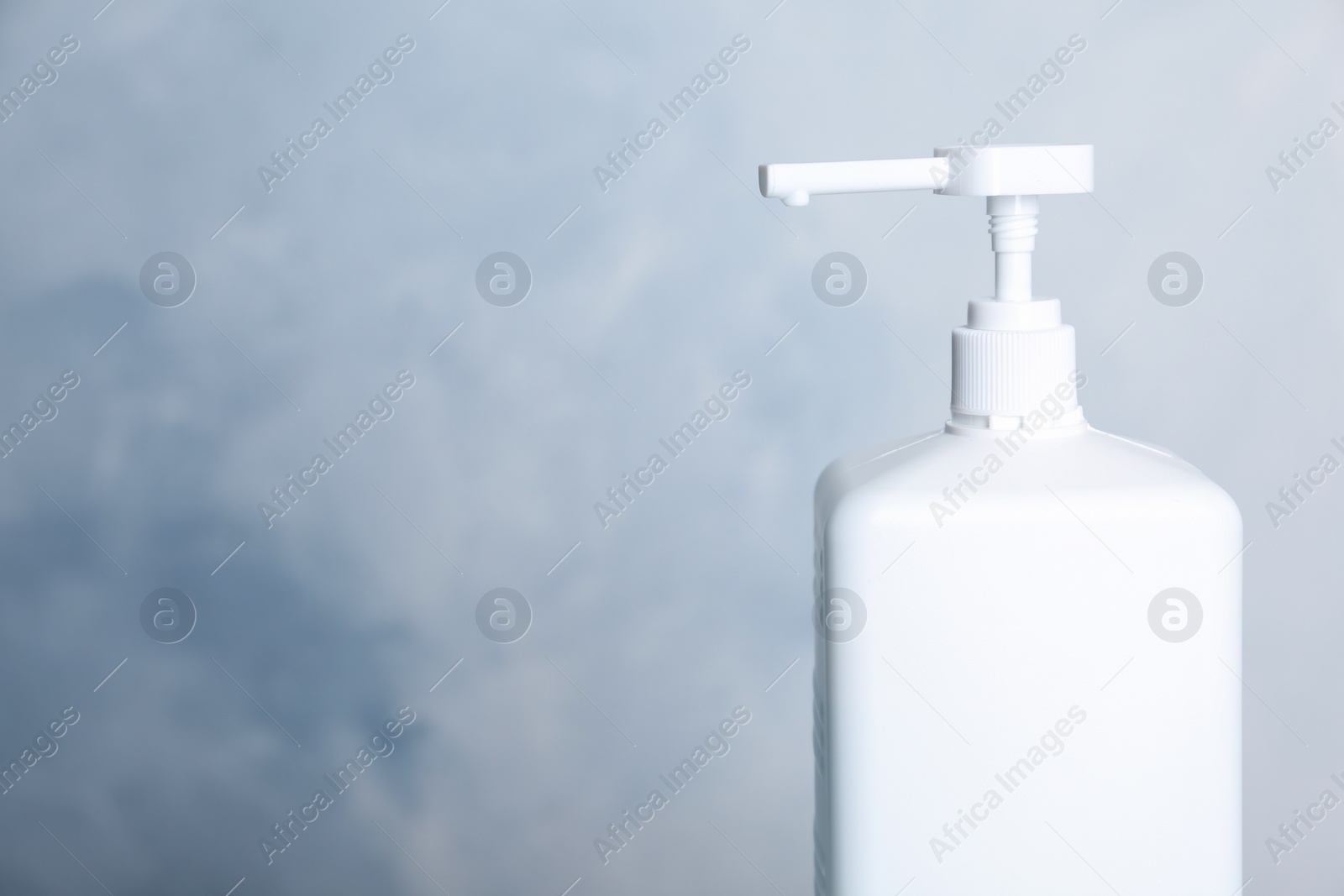 Photo of Dispenser bottle with antiseptic gel on light background, closeup. Space for text