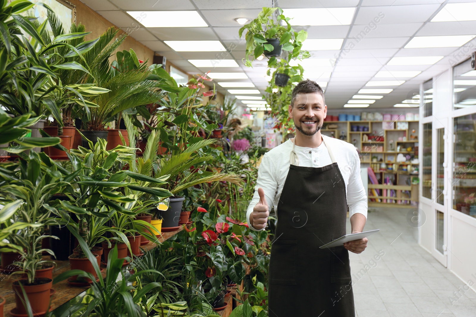 Photo of Male business owner with tablet in his flower shop