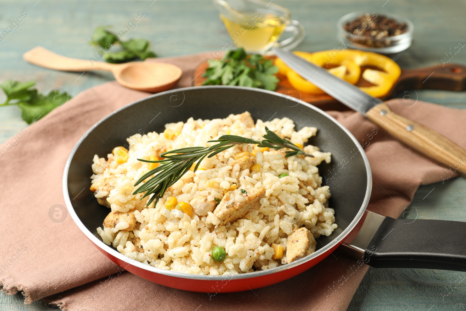 Photo of Delicious chicken risotto on light blue wooden table