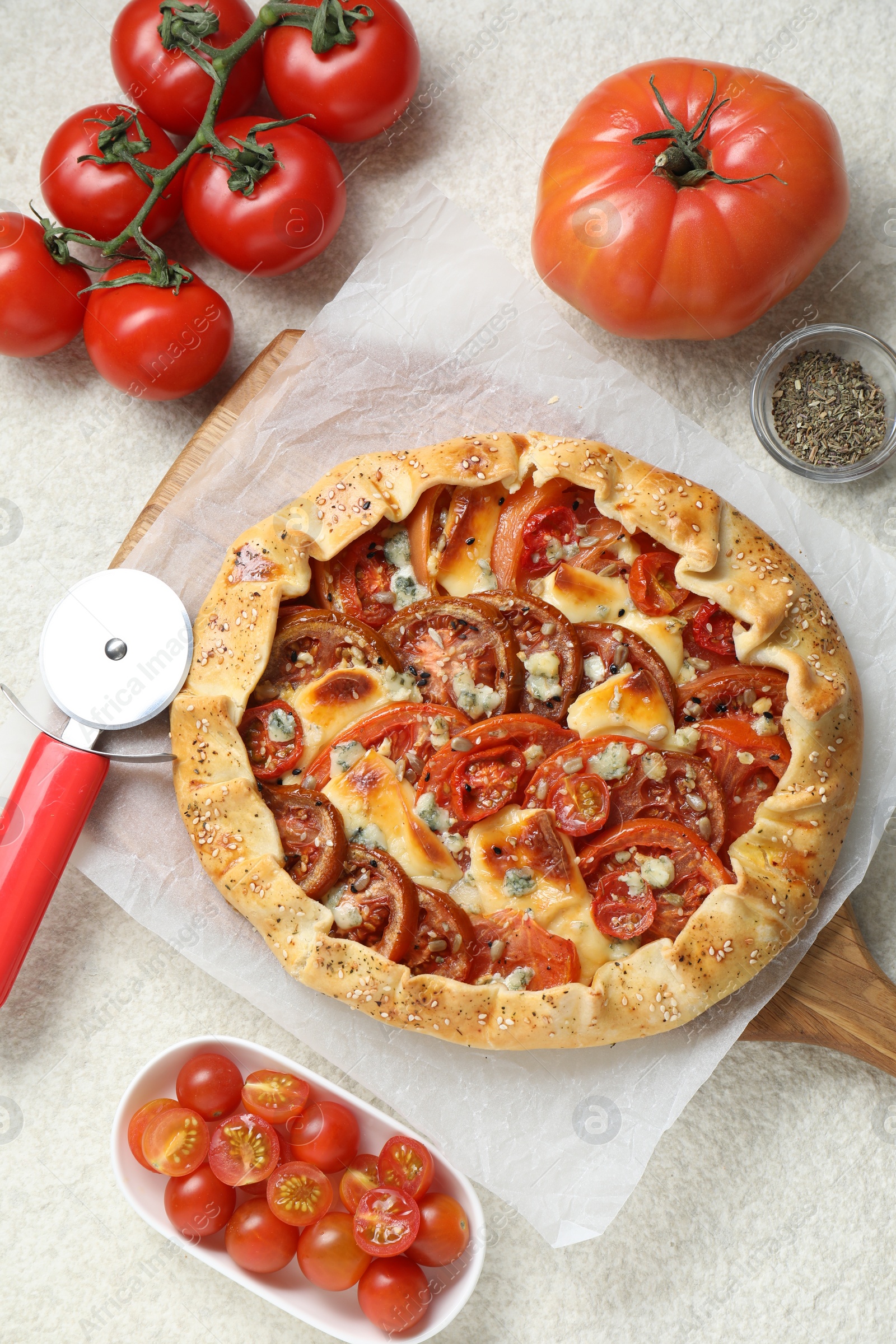 Photo of Flat lay composition of tasty galette with tomato and cheese (Caprese galette) on light textured table