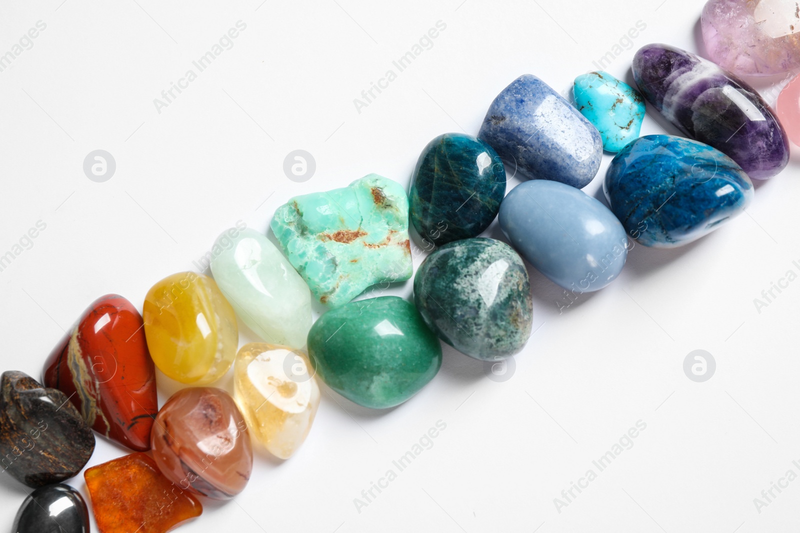 Photo of Different beautiful gemstones on white background, top view