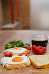 Photo of Tasty toasts with fried eggs, cheese and vegetables on wooden table indoors. Space for text