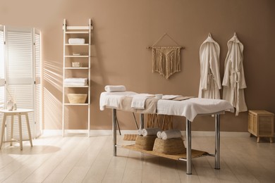 Stylish spa salon interior with massage table