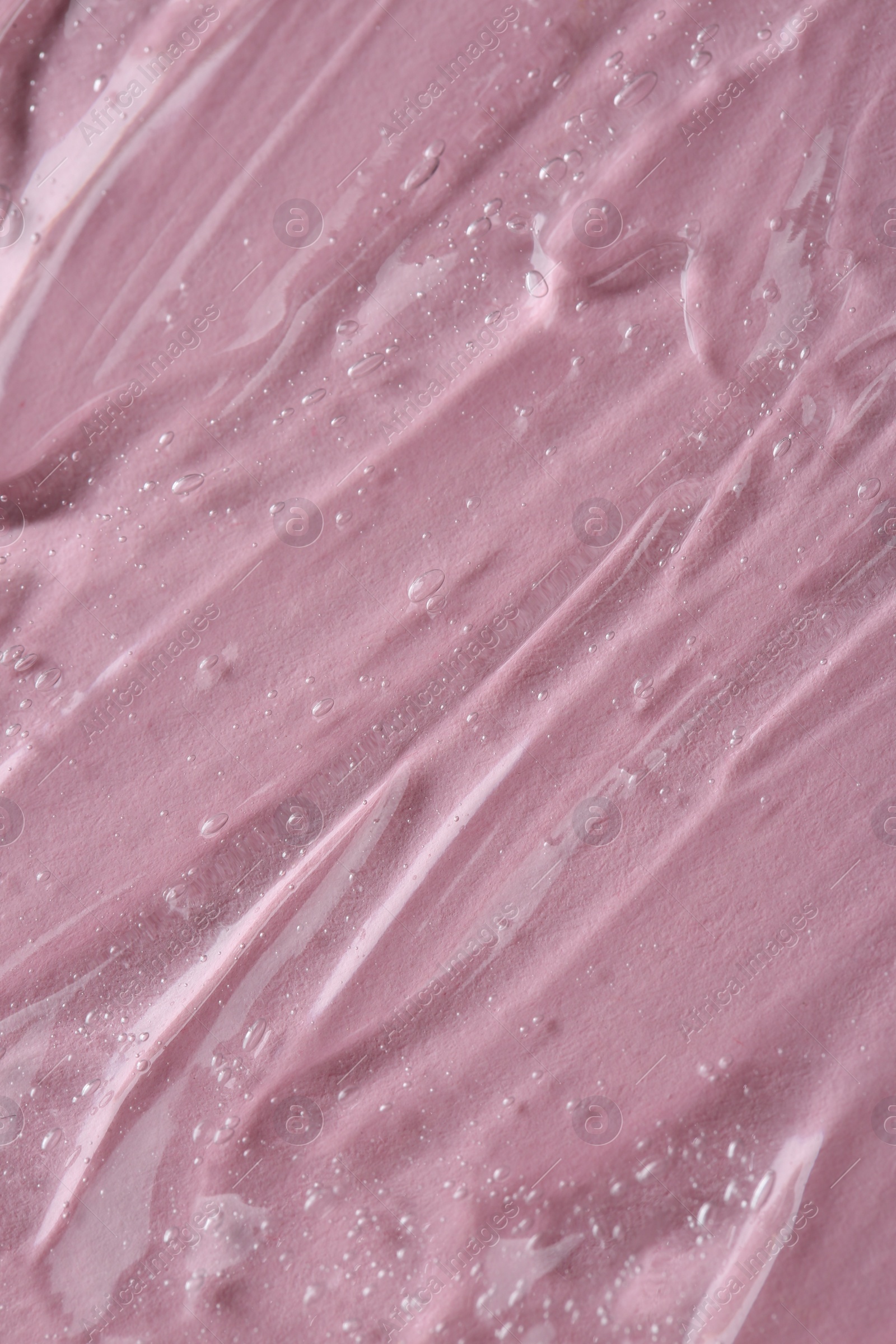 Photo of Clear cosmetic serum on pink background, macro view