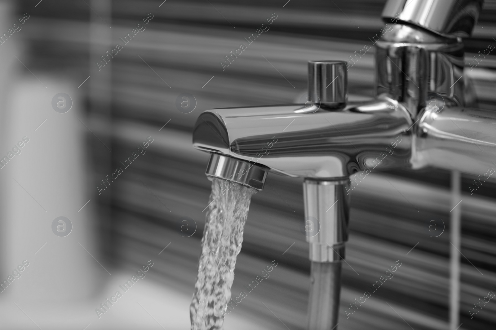 Image of Water flowing from tap in bathroom, closeup