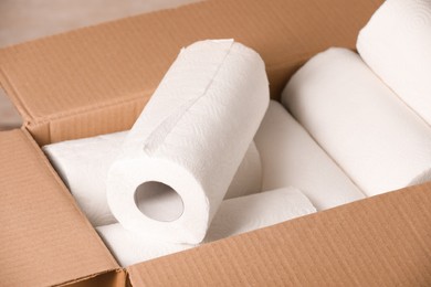 Photo of Rolls of white paper towels in cardboard box, closeup