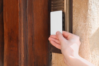Photo of Woman opening door lock with key card outdoors, closeup