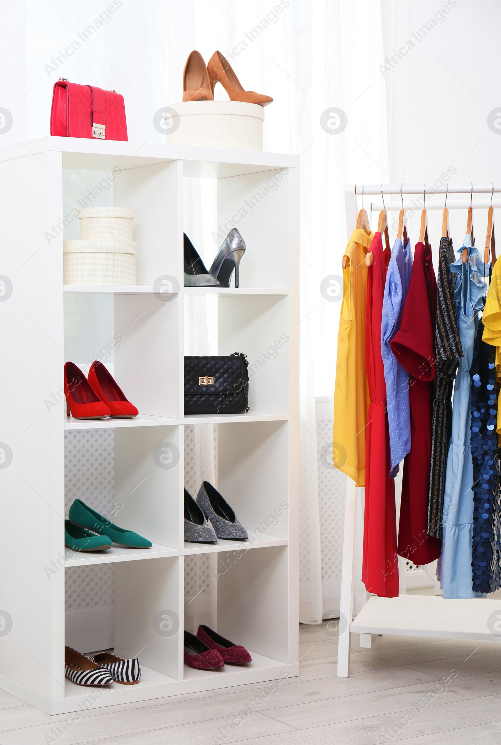 Photo of Shelving unit with shoes and purses in stylish dressing room interior