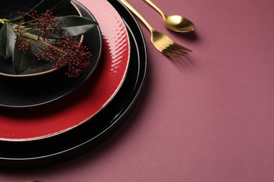 Photo of Stylish table setting with cutlery and floral decor on pink background, space for text