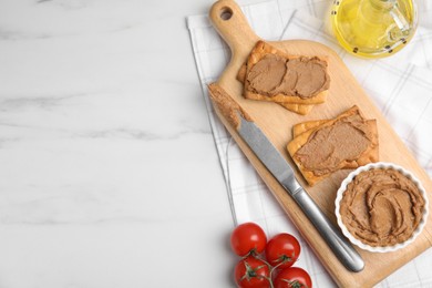 Photo of Crispy crackers with delicious meat pate served on white marble table, flat lay. Space for text