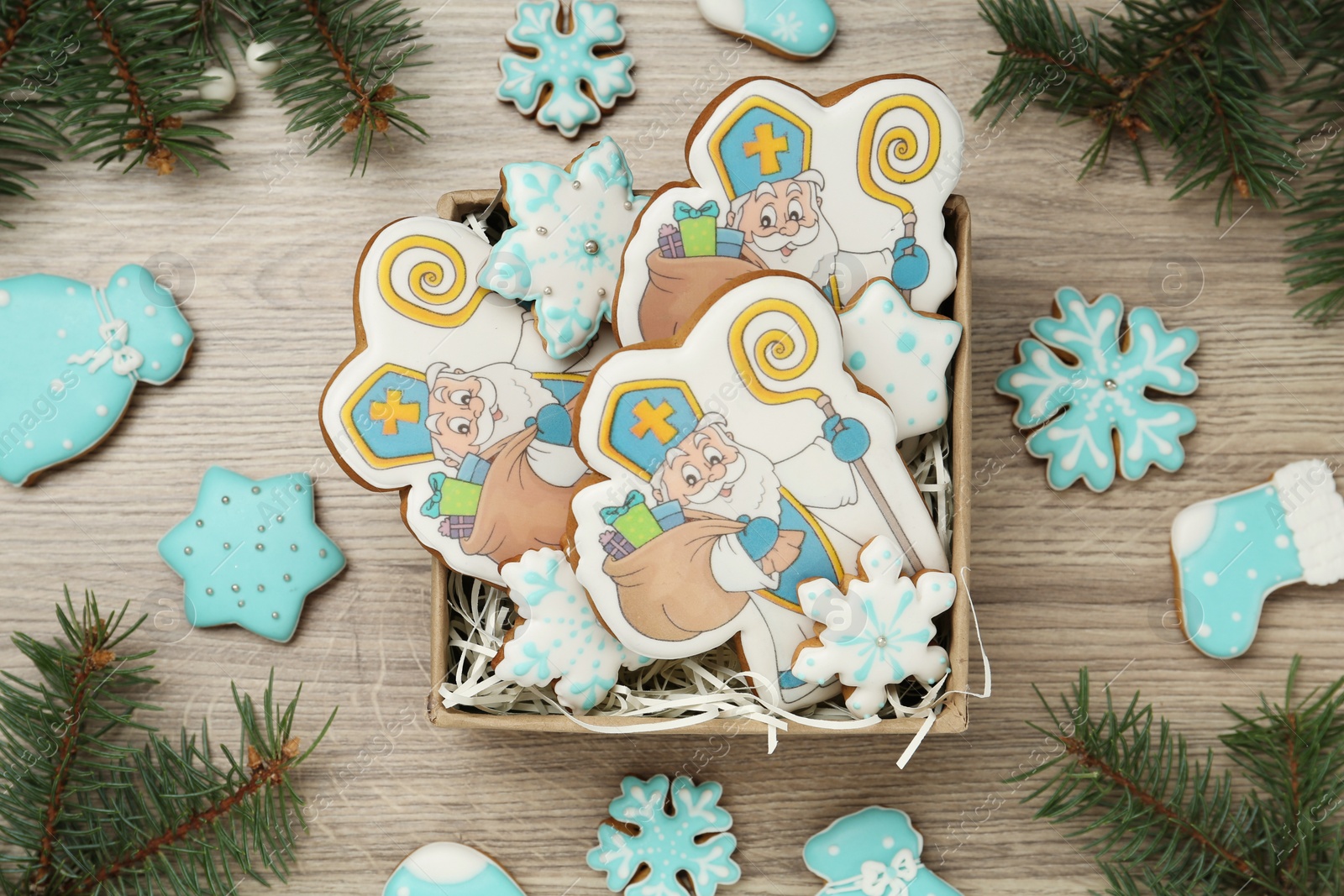 Photo of Delicious gingerbread cookies on wooden table, flat lay. St. Nicholas Day celebration