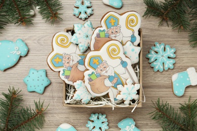 Delicious gingerbread cookies on wooden table, flat lay. St. Nicholas Day celebration