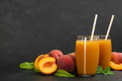 Photo of Natural freshly made peach juice on grey table. Space for text
