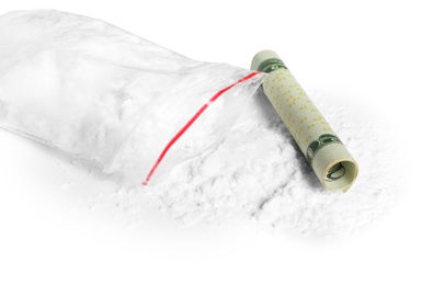 Photo of Cocaine in plastic bag and rolled money bill on white background