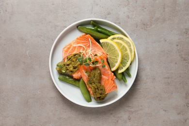 Tasty cooked salmon with pesto sauce on grey table, top view