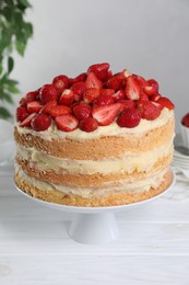 Photo of Tasty cake with fresh strawberries on white wooden table