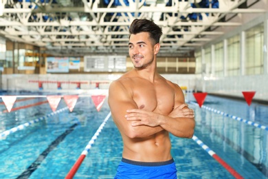 Photo of Young athletic man near swimming pool indoors