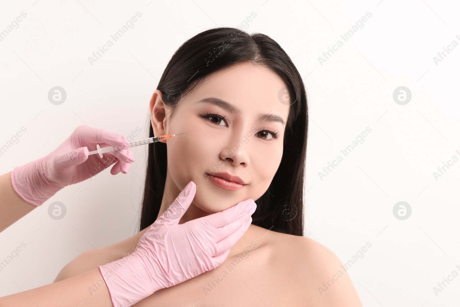 Photo of Woman getting facial injection on white background