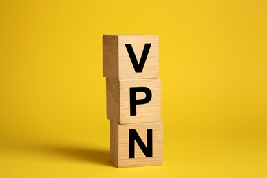 Photo of Wooden cubes with acronym VPN on yellow background