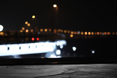 Image of Empty stone surface and blurred view of night city