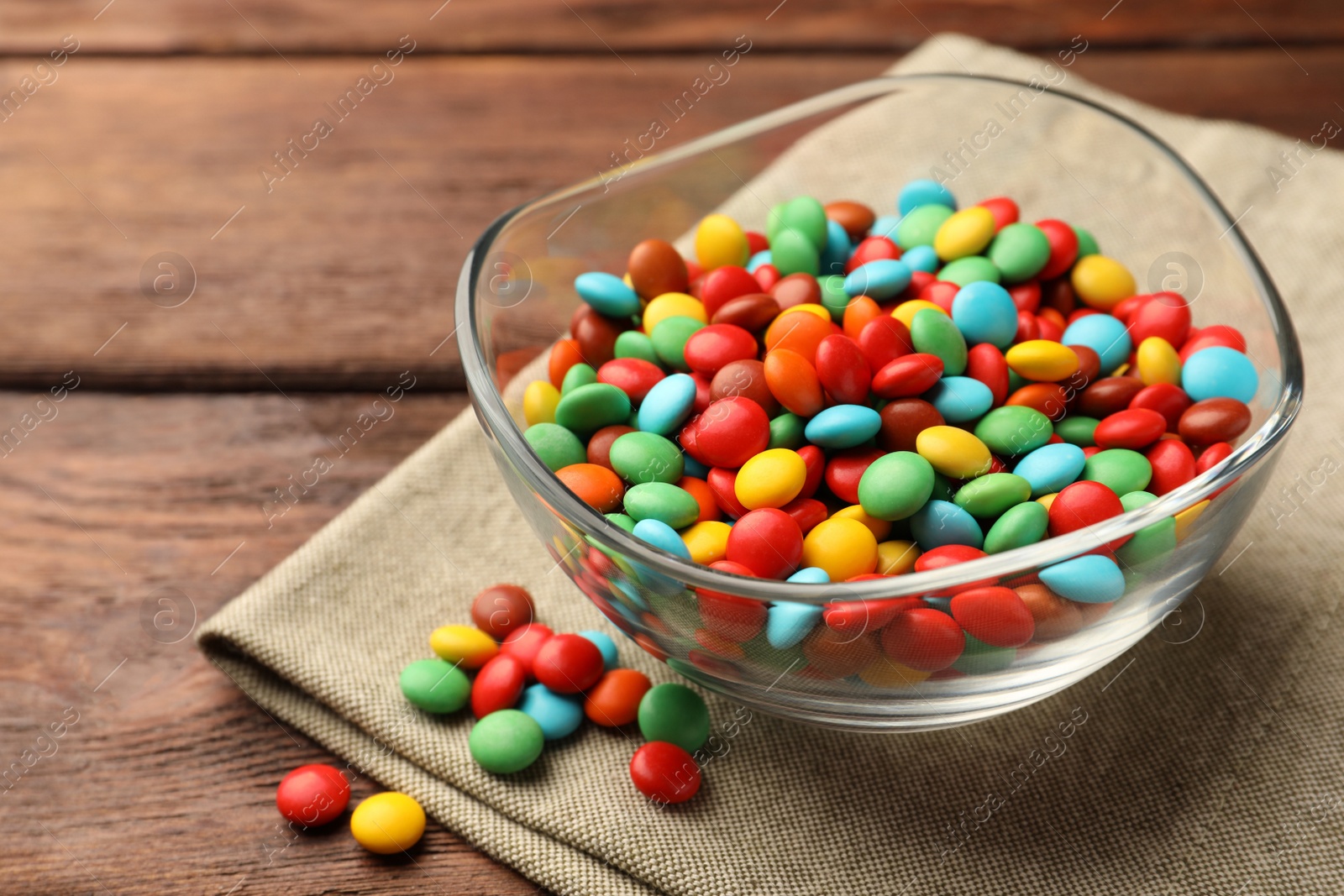 Photo of Tasty colorful candies on wooden table, closeup