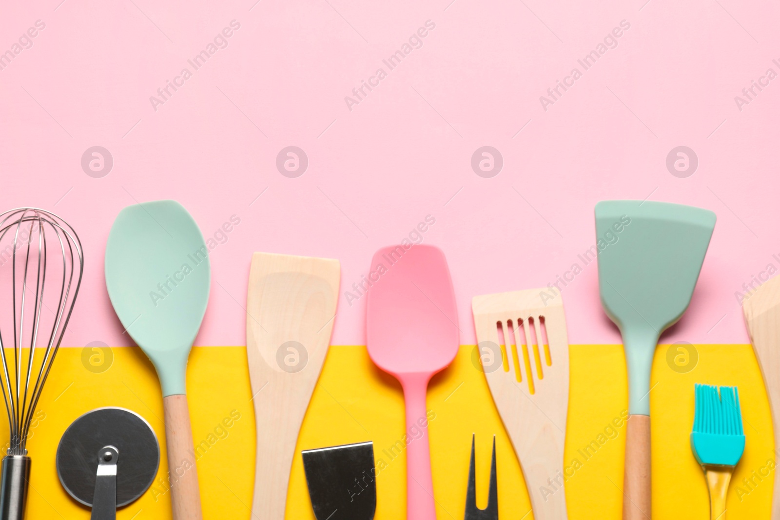 Photo of Different spatulas and other kitchen utensils on color background, flat lay. Space for text