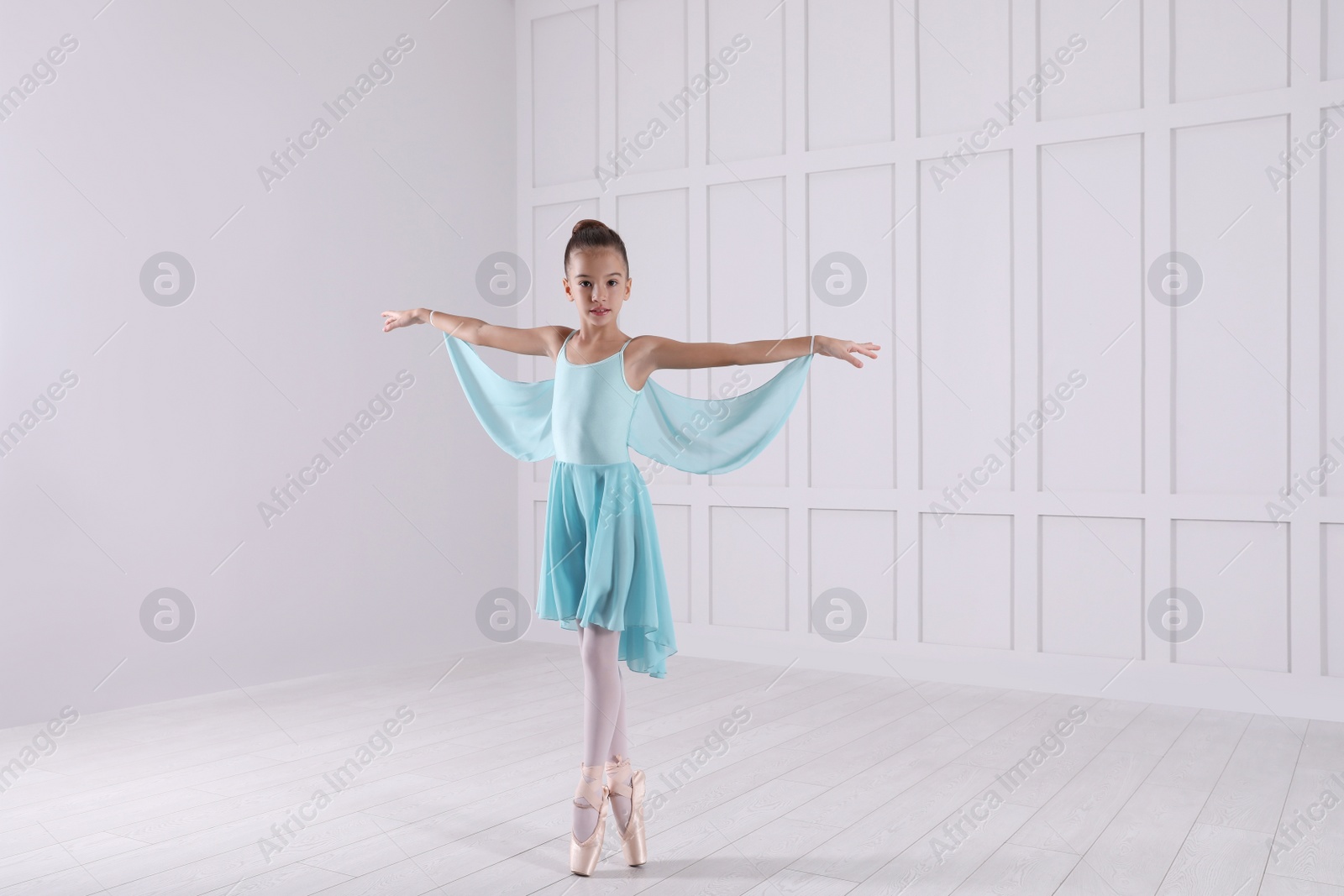 Photo of Beautifully dressed little ballerina dancing in studio. Space for text 