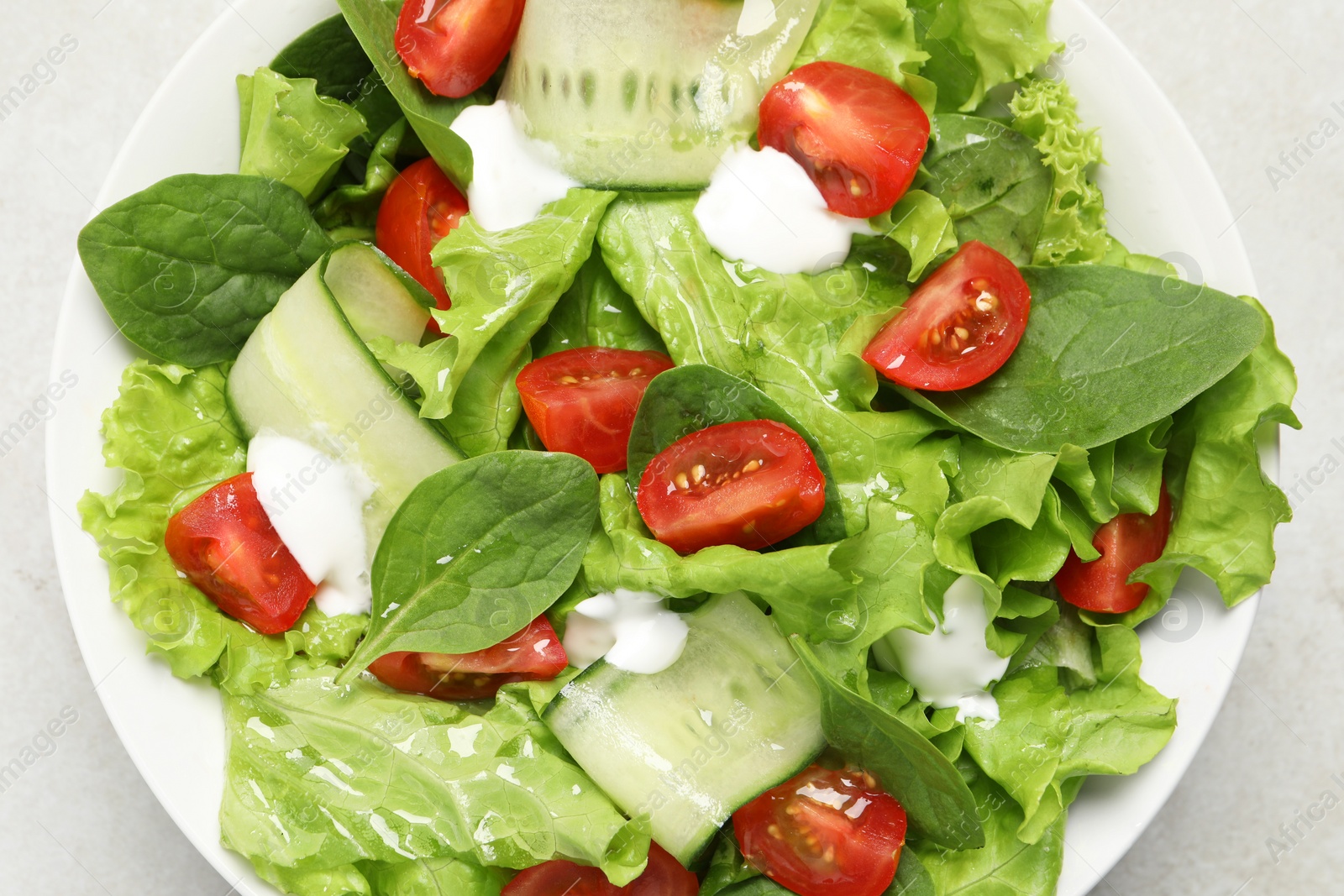 Photo of Delicious vegetable salad on light grey table, top view