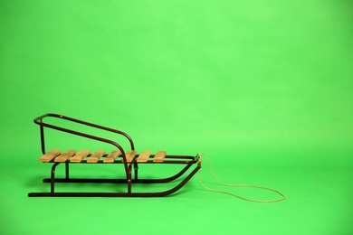 Photo of Empty sleigh on green background. Space for text